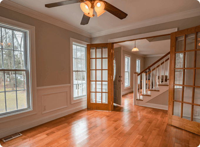 A room with hard wood floors and a ceiling fan.